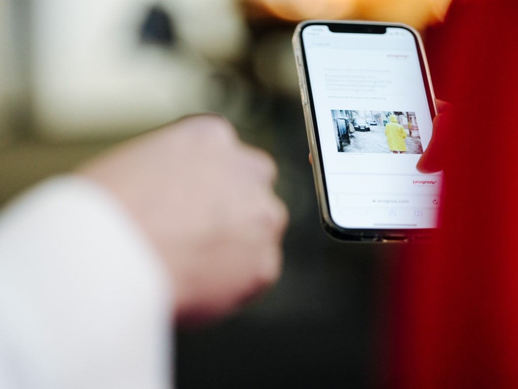 Zwei Personen zeigen auf einen Smartphone-Bildschirm