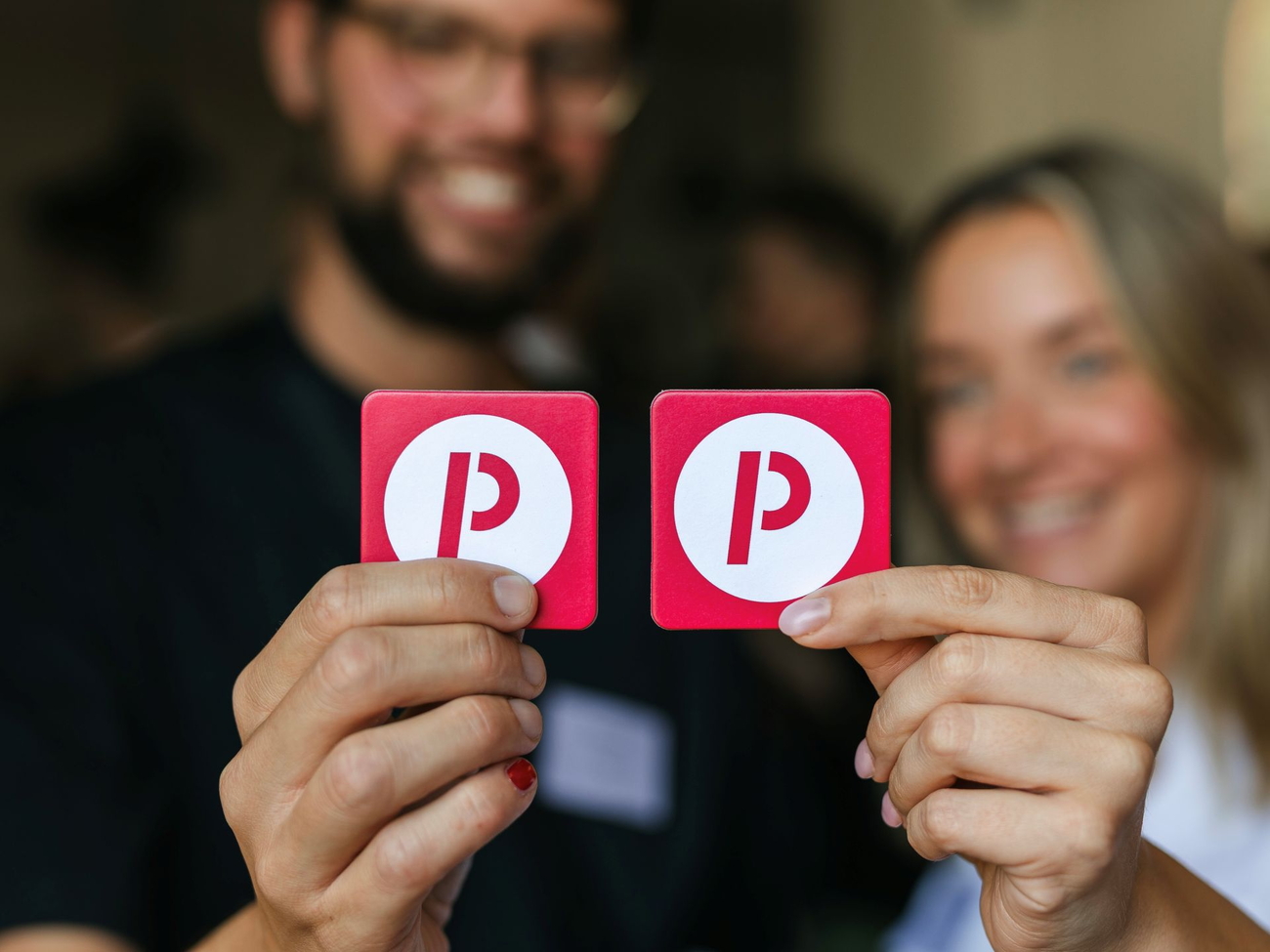 Zwei Personen zeigen ein Kartenspiel mit dem Prognos-Logo