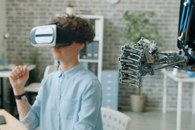 Frau mit VR-Brille und Roboter bewegen simultan die Hände