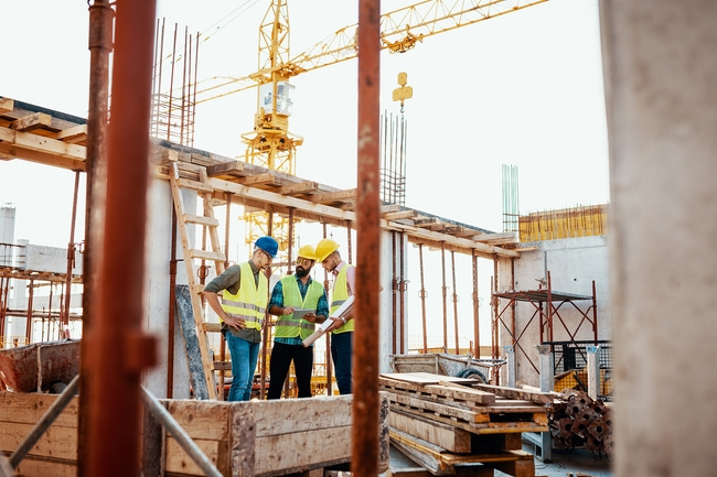 Erfahrener Ingenieur erklärt die Probleme bei Bauarbeiten. Teamwork auf der Baustelle.