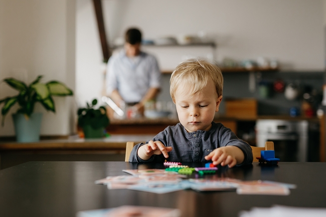 Sohn eines alleinerziehenden Vaters, der mit Spielzeugblöcken spielt 