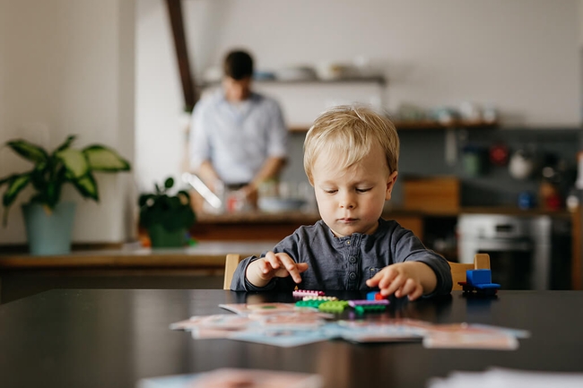 Sohn eines alleinerziehenden Vaters, der mit Spielzeugblöcken spielt 