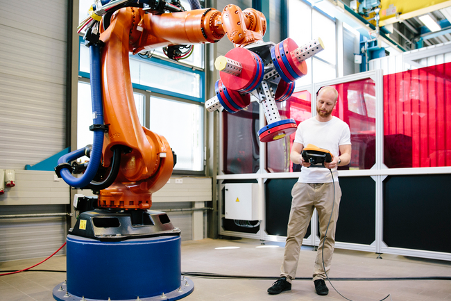 Industrie 4.0: Junger Ingenieur arbeitet an einem Roboterarm