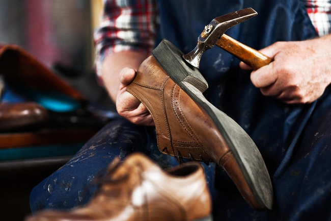 Ein Mann repariert Schuh