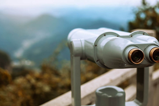 Blick auf die Berge durch ein Fernglas