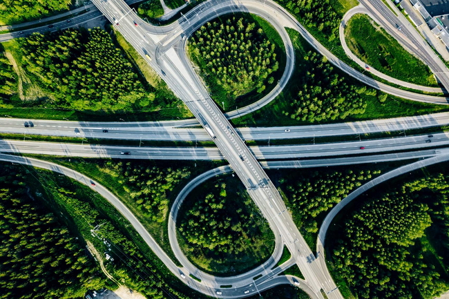 Luftaufnahme von Autobahn und Überführung mit grünen Wäldern