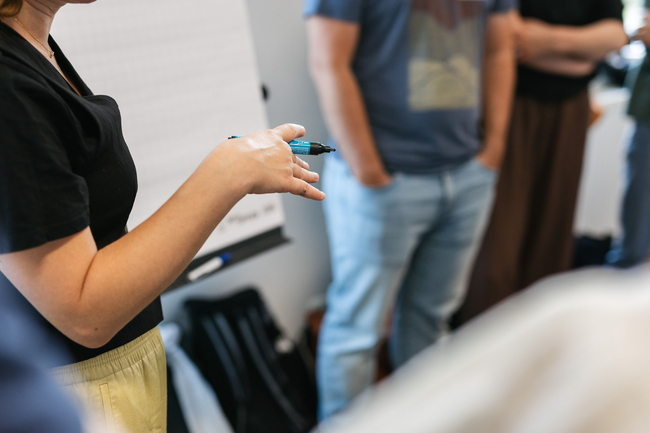 Gruppe diskutiert an einer Flipchart