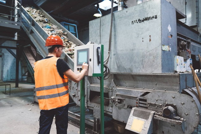 Person arbeitet in einer Müllverbrennungsanlage