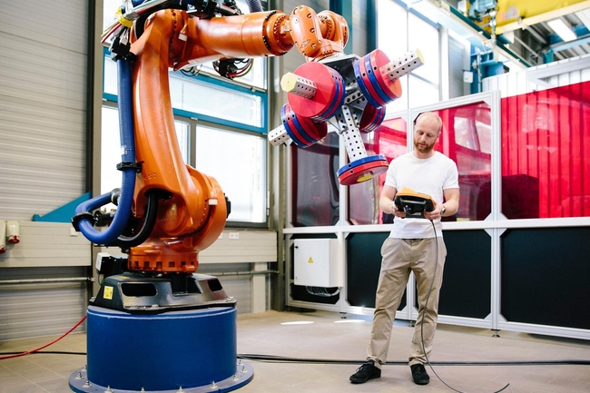 Industrie 4.0: Junger Ingenieur arbeitet an einem Roboterarm