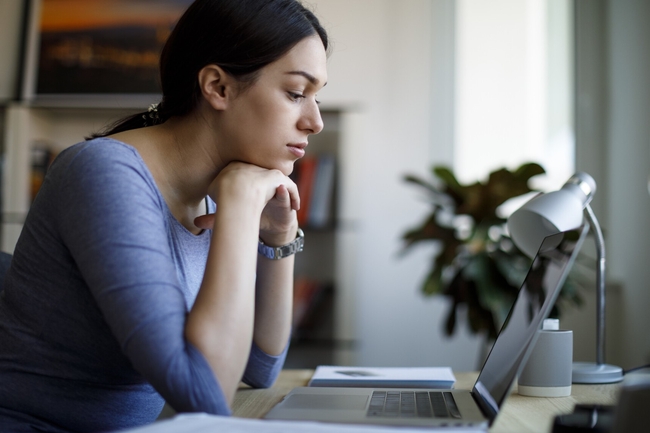 Junge Frau sitzt an ihrem Schreibtisch im Home Office