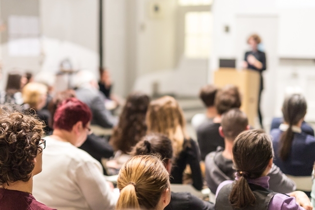 Eine Person hält einen Vortrag vor Studierenden