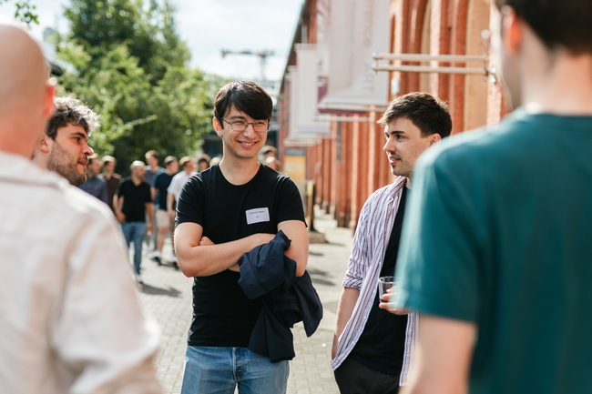 Junger Mitarbeiter spricht mit Kollegen