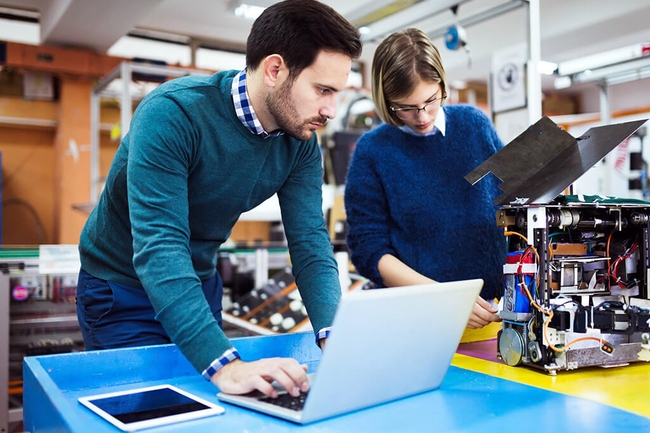 Zwei Menschen arbeiten an einem Werktisch