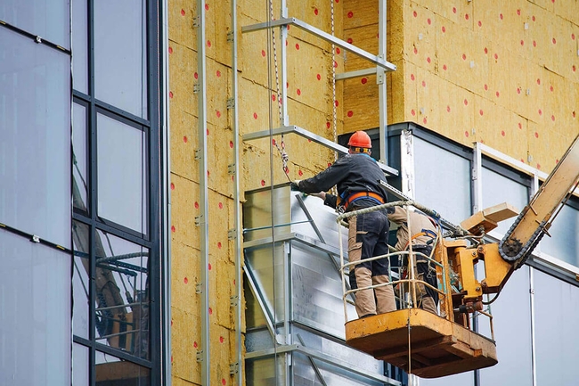 Bauarbeiter dämmen ein Haus