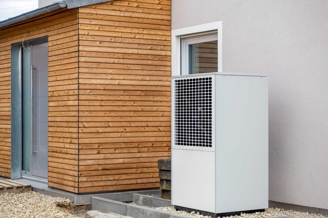 Eine Wärmepumpe ist an der Außenseite einer Hauswand installiert.