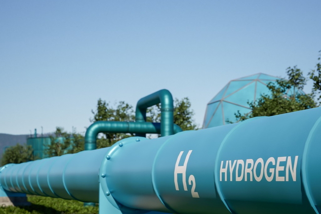 Blaue Wasserstoff-Pipeline im Freien mit „HYDROGEN“-Aufschrift und H2-Logo.