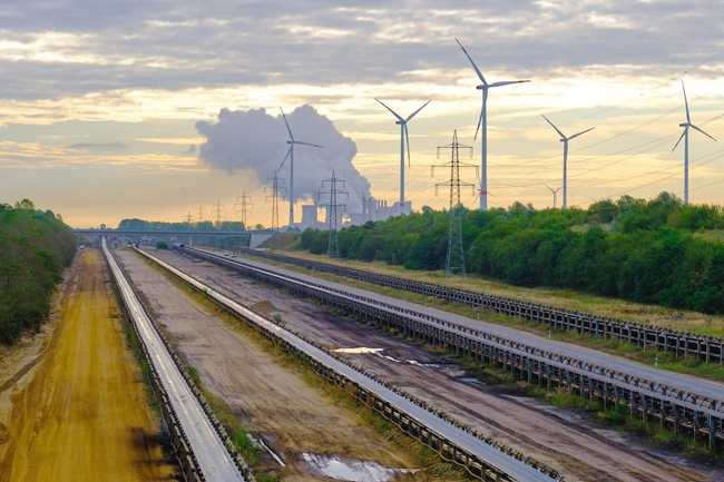 Autobahnen, im Hintergrund Stromleitungen, Windkraftanlagen und Industrie