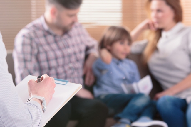 Familie sitzt auf einem Sofa und lässt sich beraten