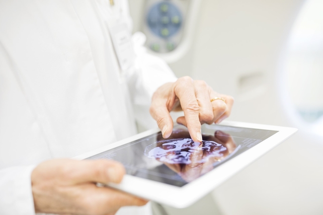 Arzt oder Forscher in einem weißen Kittel, der ein Tablet in den Händen hält