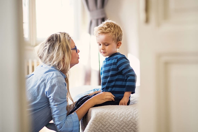 Junge Mutter spricht zu ihrem kleinen Sohn