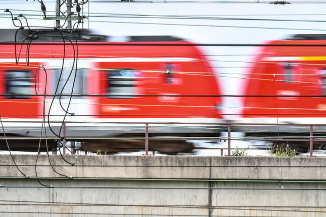 Ein unscharfes Bild einer fahrenden roten Regionalbahn in Nahaufnahme.