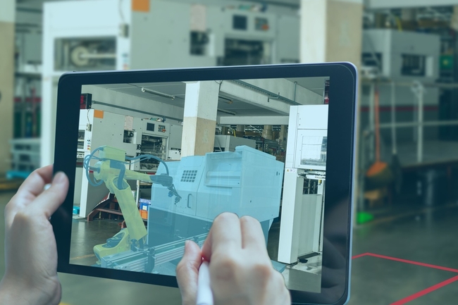 Auf einem Tablet ist ein digitaler Zwilling in einer Fabrik zu sehen