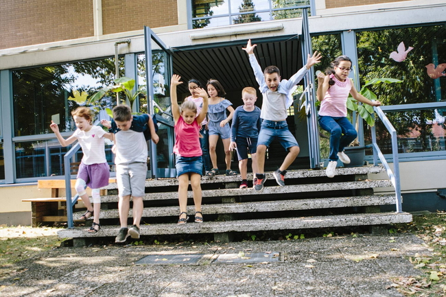 Schulkinder laufen von der Schule zum Schulhof