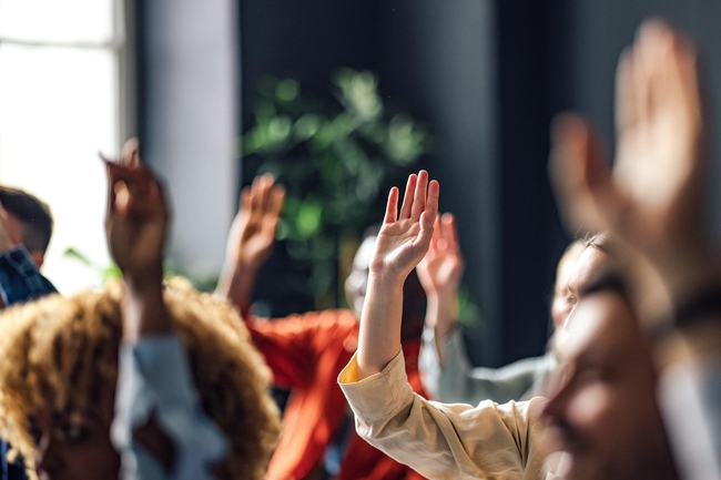 Menschen heben ihre Hand im Gespräch