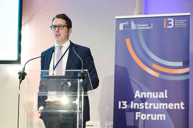 Dr. Jan-Philipp Kramer spricht am Rednerpult vor Banner des I3 Instrument Forum.