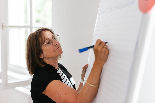 Person schreibt auf einem Flipchart