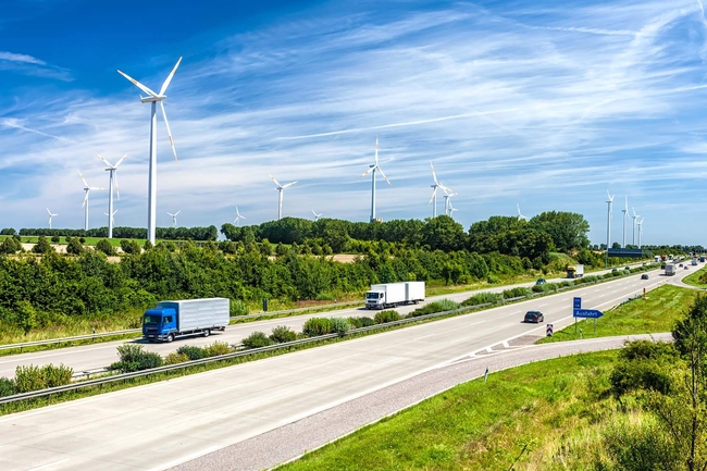 Verkehr auf der Autobahn, im Hintergrund Windkraftanlagen