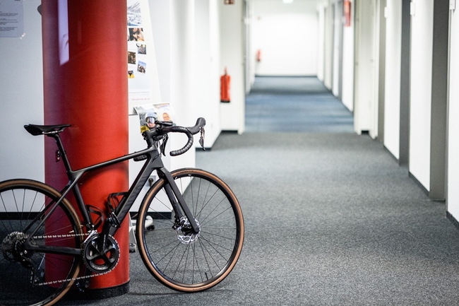 Schwarzes Sportrad lehnt an roter Säule im Berliner Prognos-Büro