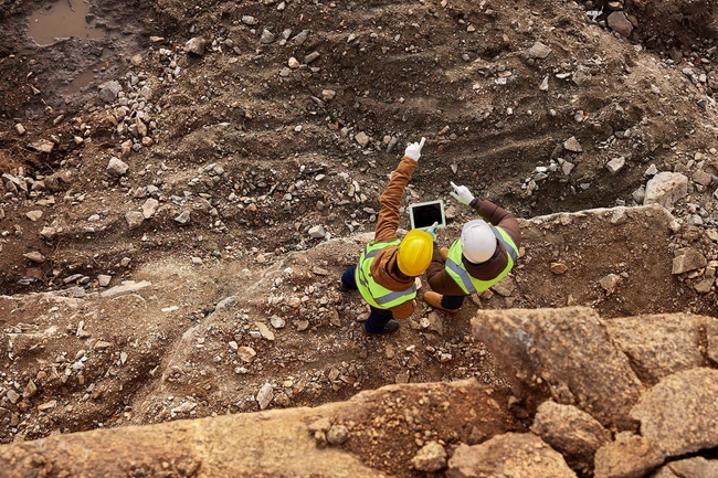 Zwei Industriearbeiter begutachten eine Bergbaustelle