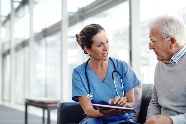 Eine Ärztin erklärt einem Patienten am Tablet etwas