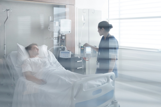 Eine Mitarbeiterin eines Krankenhauses schaut nach einem Patienten.