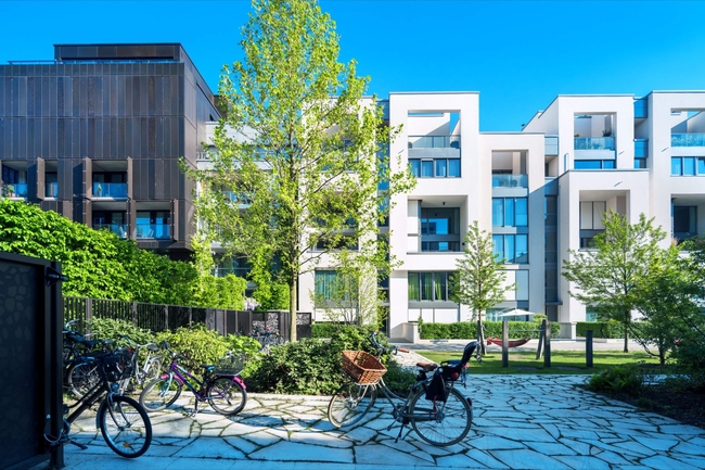 Fahrräder abgestellt vor neugebauten Apartement-Wohnhäusern