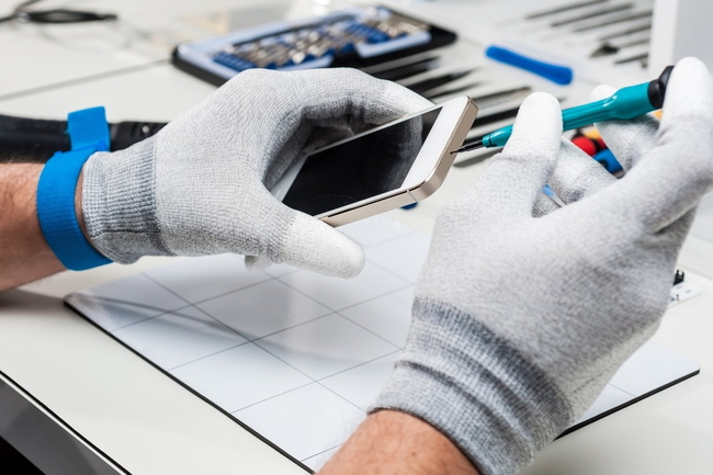 Person repariert ein gebrauchtes Smartphone