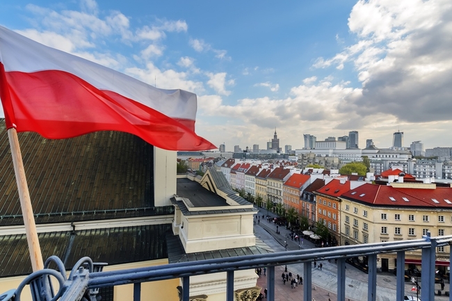 Eine polnische Flagge weht auf einem Balkon, im Hintergrund Häuser