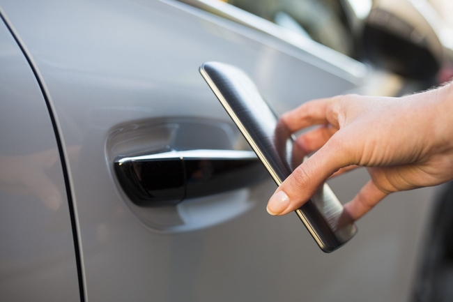 Eine Person schaltet ein Mietauto mit dem Smartphone frei