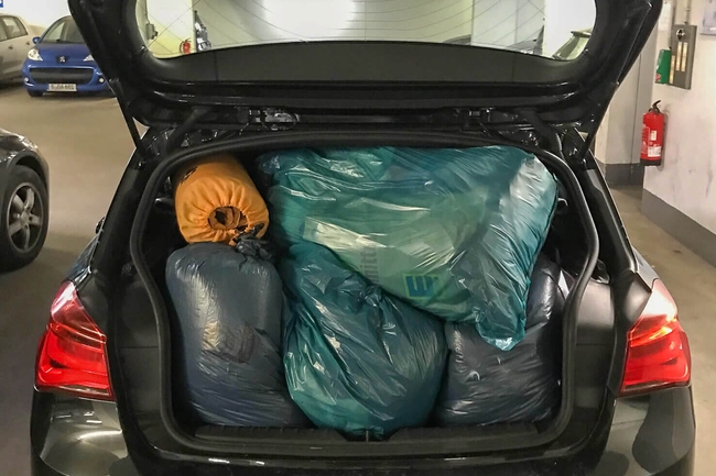 Vollgeladener Kofferraum eines Autos mit Kleiderspenden