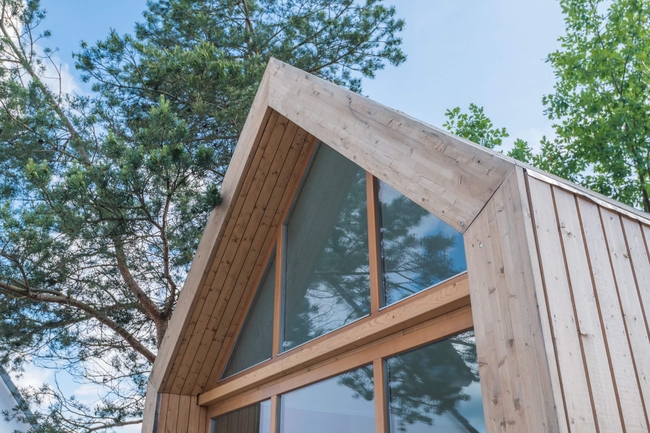 Modernes, isoliertes Haus in Holzoptik mit verglaster Front