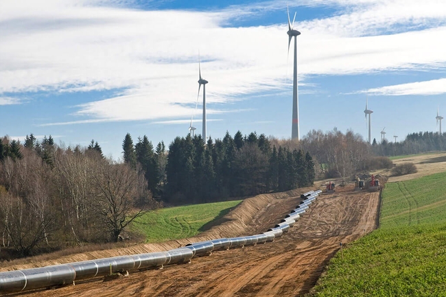 Rohrleitungsbau in hügeliger Landschaft - Rohre vor der Verlegung