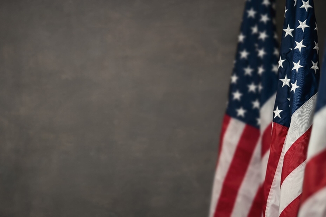 eine US-amerikanische Flagge vor einem grauen Hintergrund