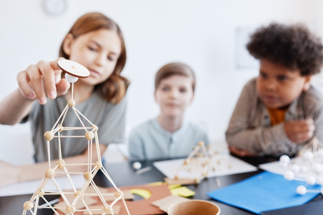 Teenager-Kinder, die im Kunst- und Handwerksunterrichts in der Schule Holzmodelle herstellen