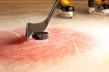 Eishockey Spieler schlägt an einen Puck