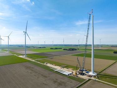 Windkraftanlagenbau mit riesigen Kränen in einem neuen Windpark