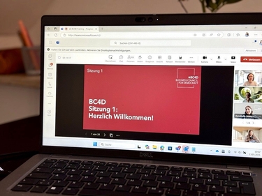 Ein Bildschirm auf einem Schreibtisch zeigt die Startfolie der BC4D-Schulungsreihe 