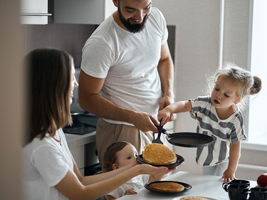 Familie mit zwei Kindern beim Frühstück