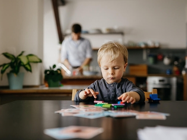 Sohn eines alleinerziehenden Vaters, der mit Spielzeugblöcken spielt 