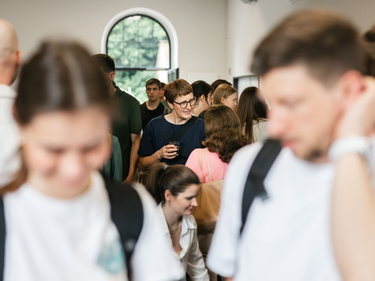 Blick in die Menge bei einer internen Firmenveranstaltung. Menschen unterhalten sich.